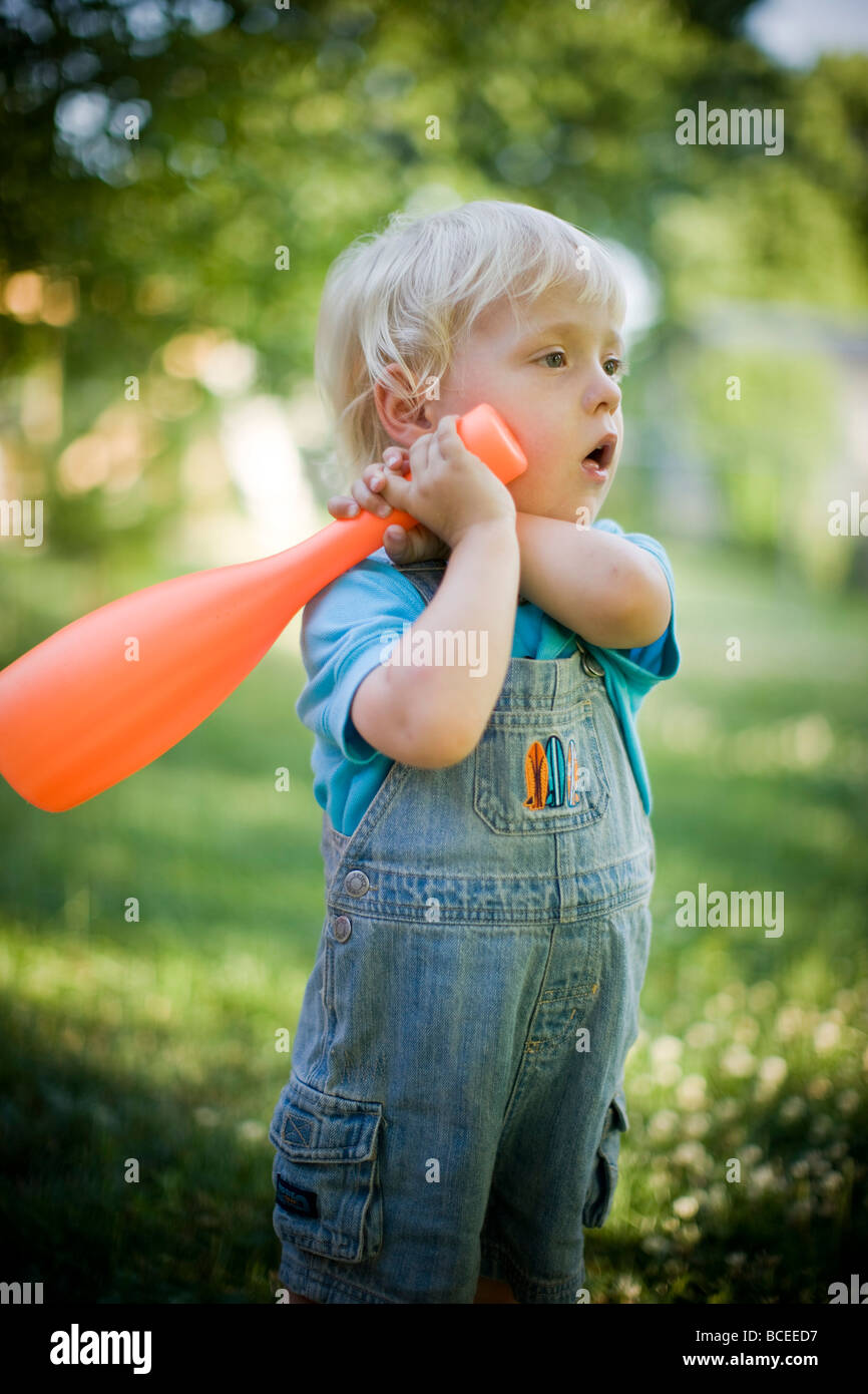 Toddler playing outdoors with a baseball bat Stock Photo