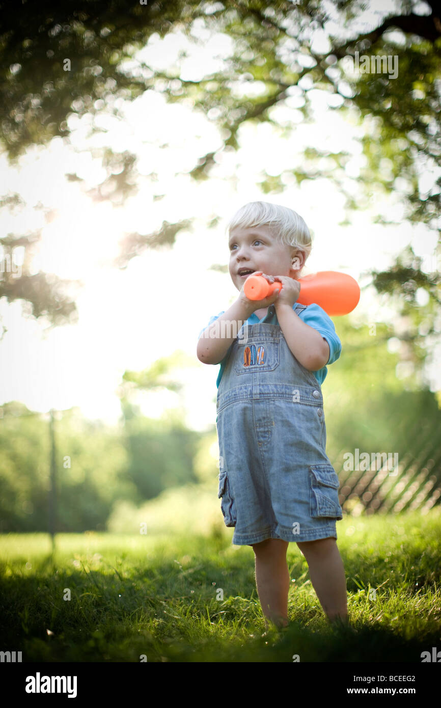 Toddler playing outdoors with a baseball bat Stock Photo