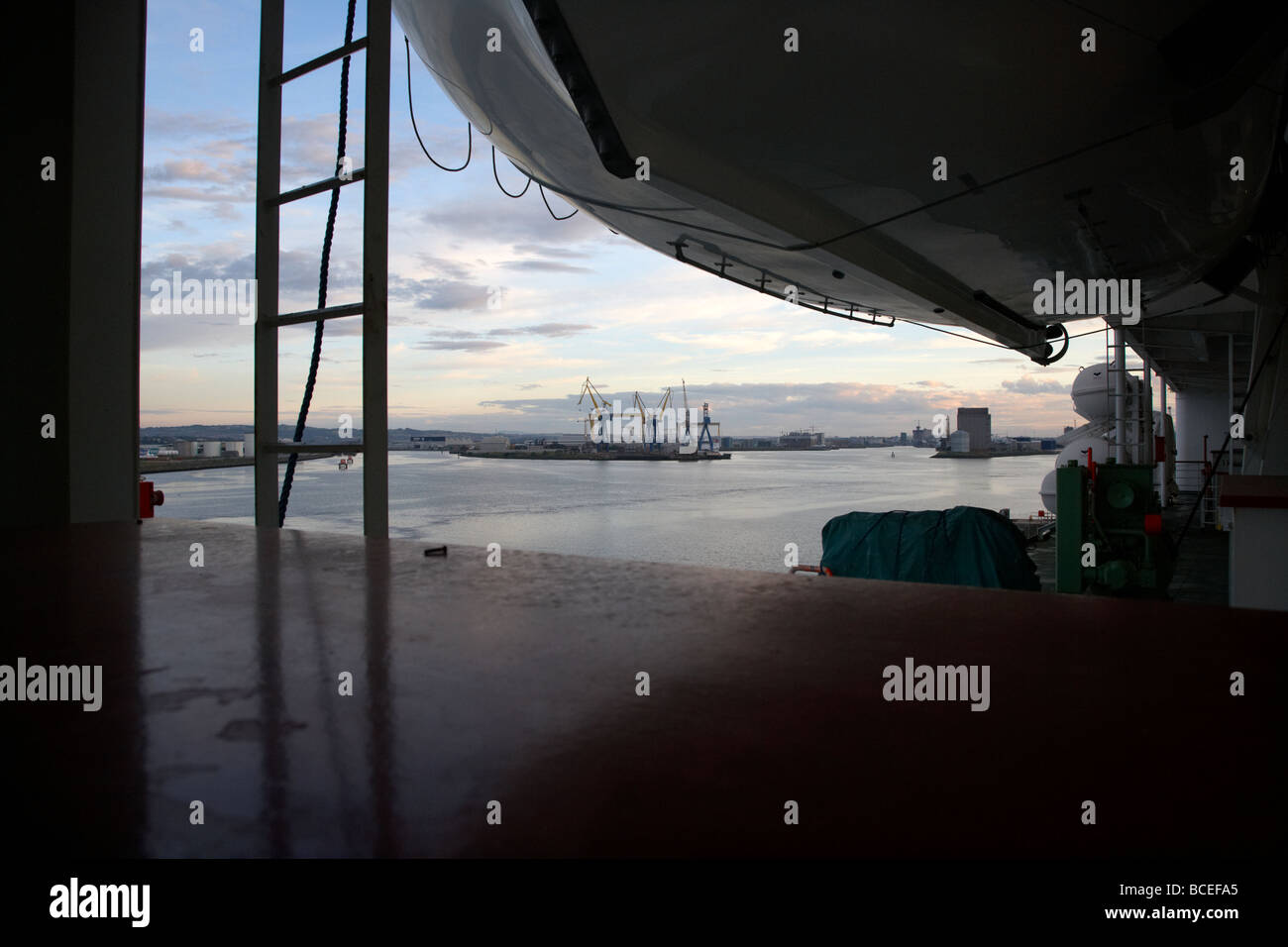 looking out under lifeboats on the side of a passenger ferry towards ...