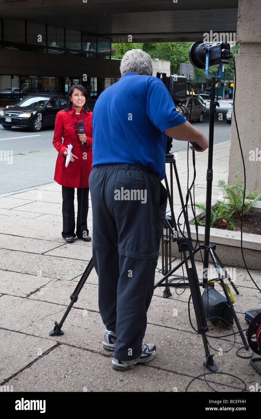 cameraman filming TV reporter for Global TV at Robson Square, Vancouver, BC, Canada Stock Photo