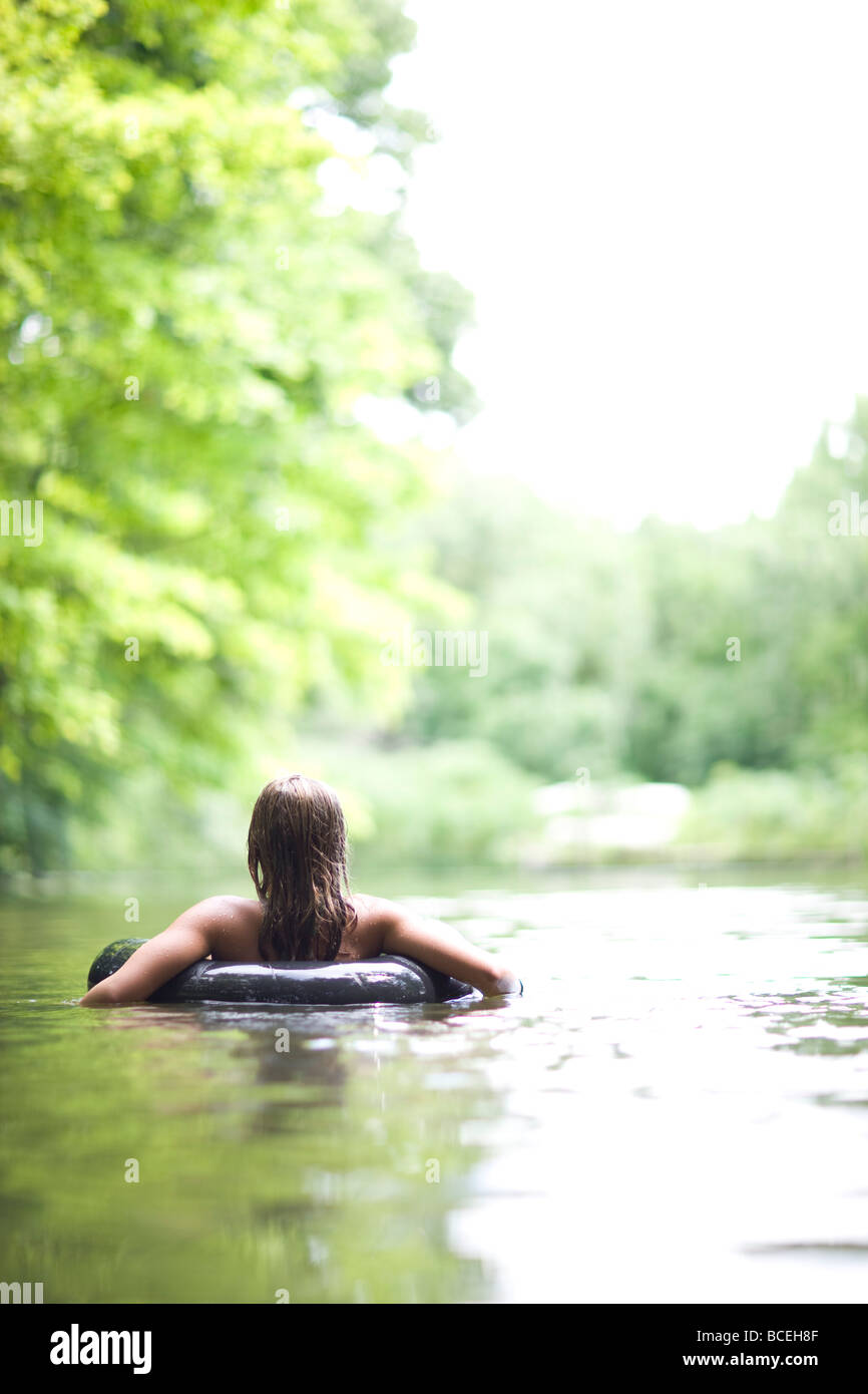 Girl sitting alone in the water in an innertube Stock Photo