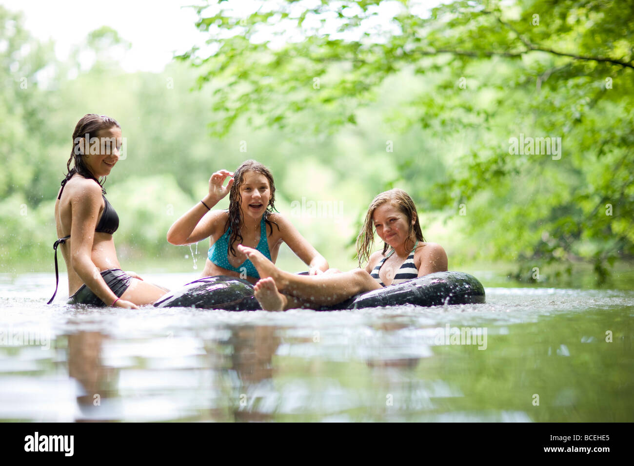 Teenagers having fun in innertubes in the water Stock Photo