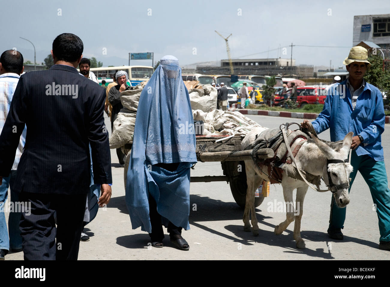 A mix of clothes and cultures from business suit to blue burqa to donkey cart in a busy Kabul street, Afghanistan's capital Stock Photo