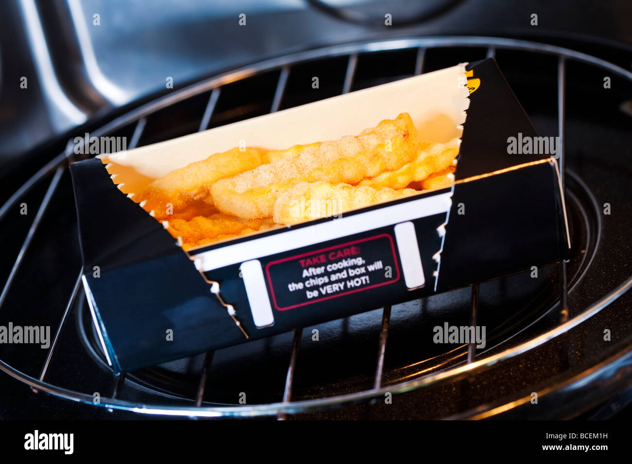 Box of McCain Micro Chips a microwaveable potato chip product inside a domestic microwave oven Stock Photo