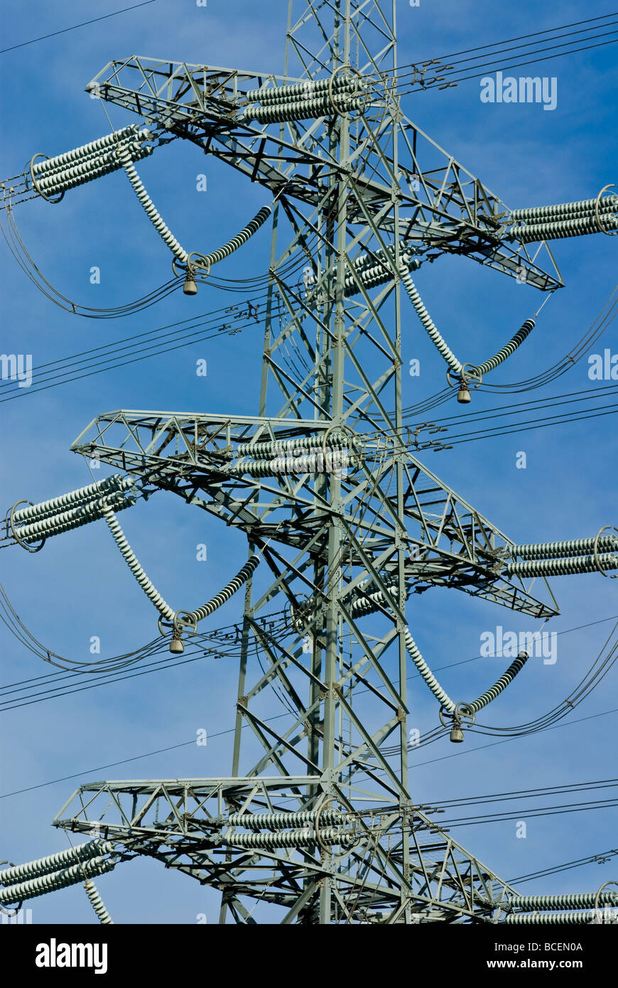 High voltage power lines on a massive steel tower carry electricity Stock Photo Alamy