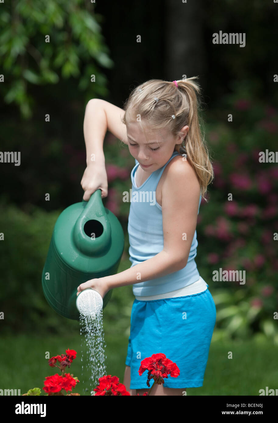 Young girl watering flowers Stock Photo - Alamy