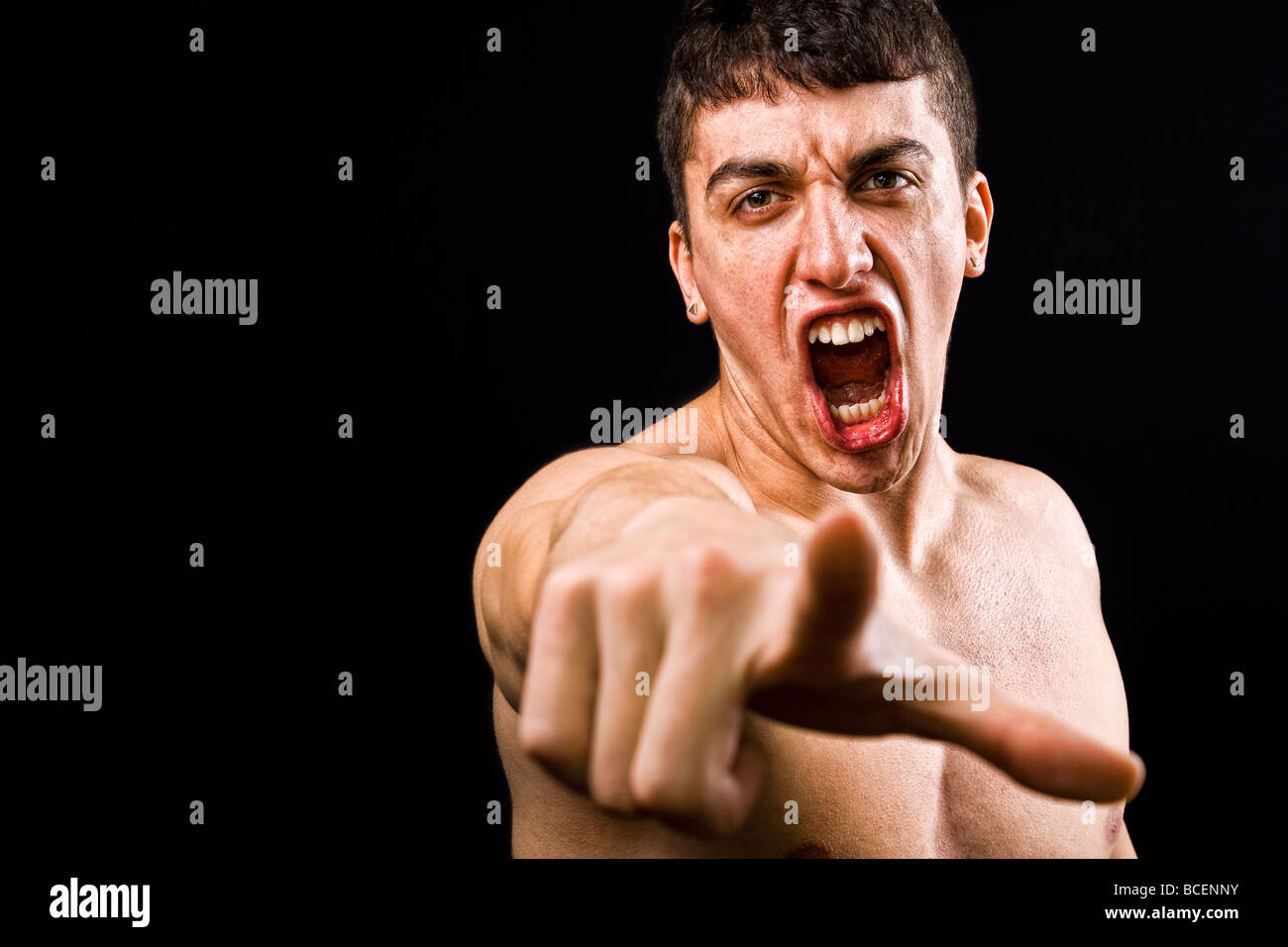 Loud scream of angry furious violent man pointing towards camera Stock Photo