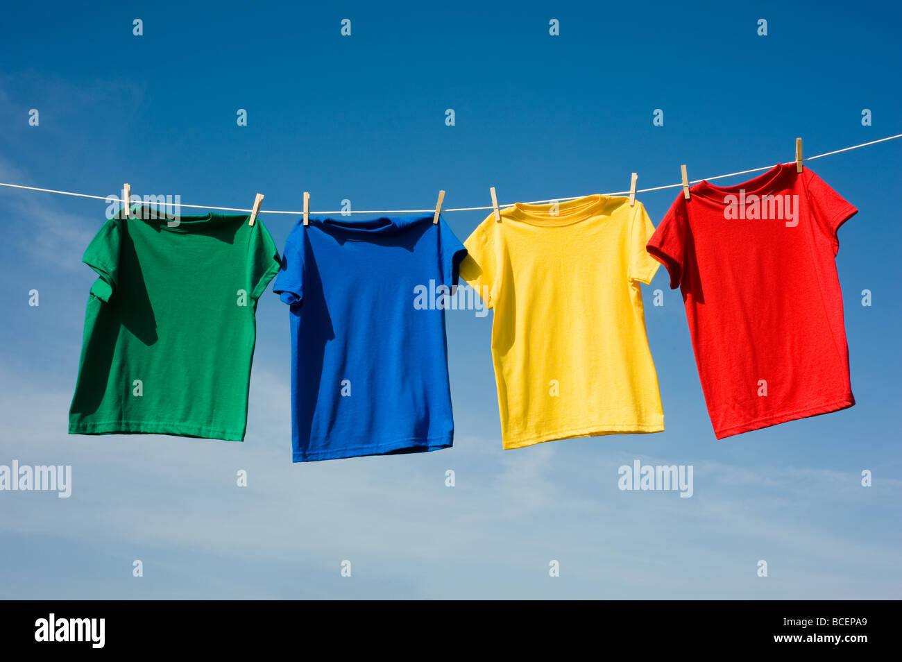 a set of primary colored T shirts hanging on a clothesline on a beautiful  sunny day add text or graphic to shirts or copy space Stock Photo - Alamy