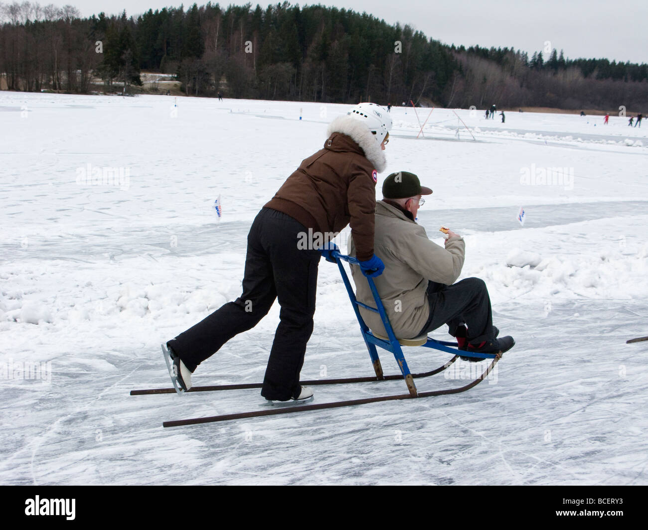 Elderly couple with a kick-sled on a lake in Sweden Stock Photo