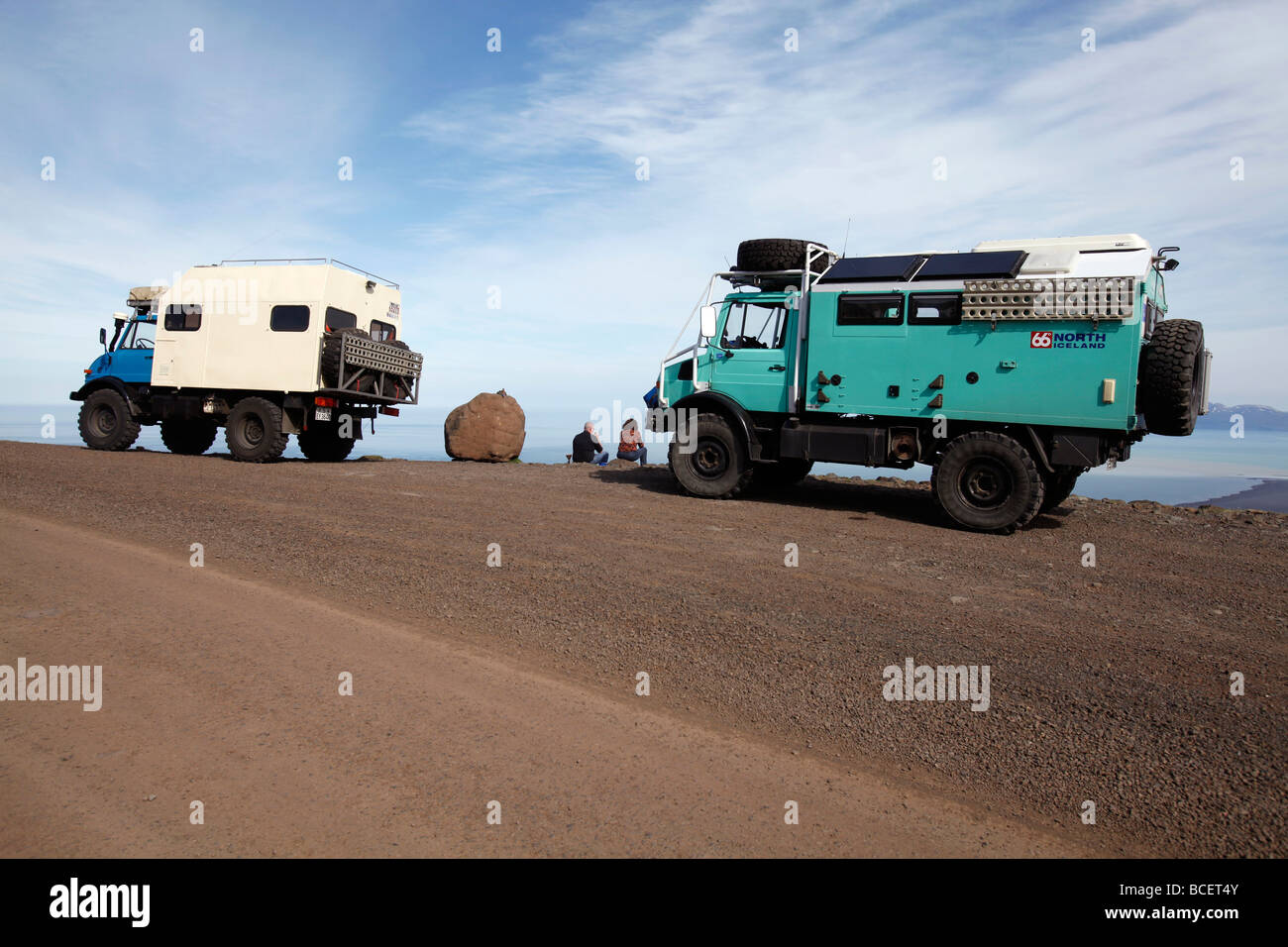 Two rugged off road vehicles stop at an overlook on a mountain road in northeast Iceland. Stock Photo