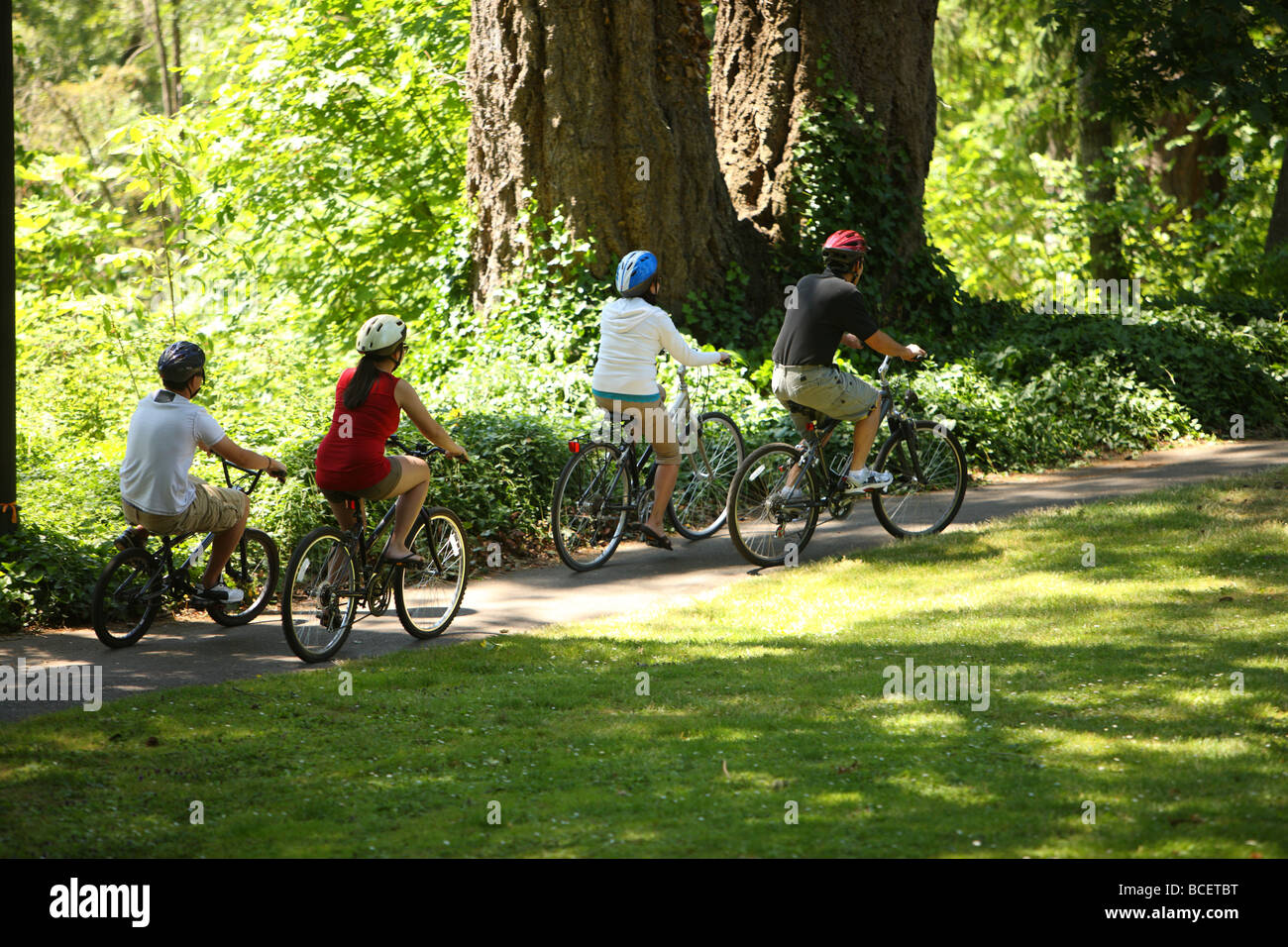 Family riding bicycles at park Stock Photo