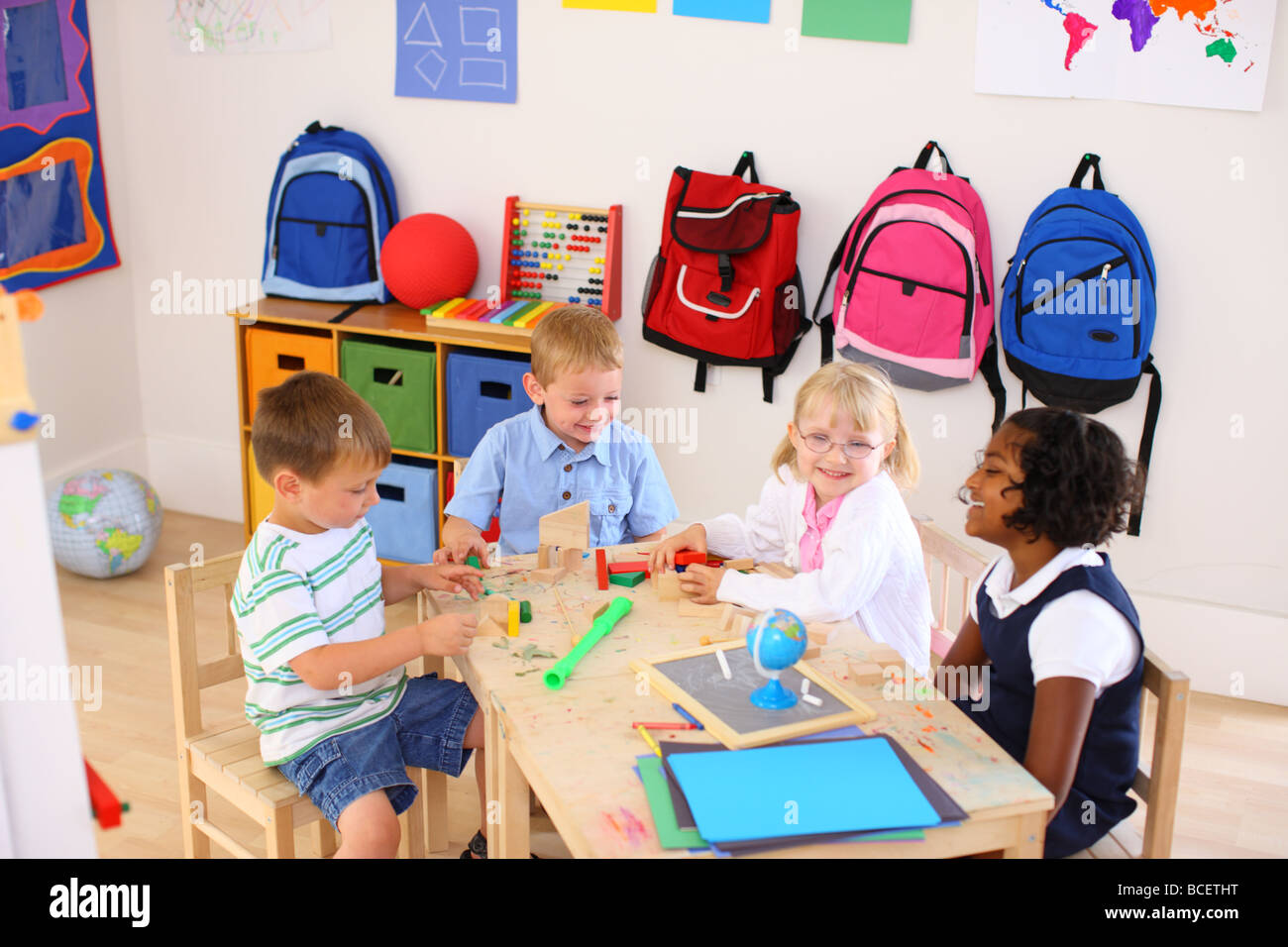 Four kids playing in preschool classroom Stock Photo