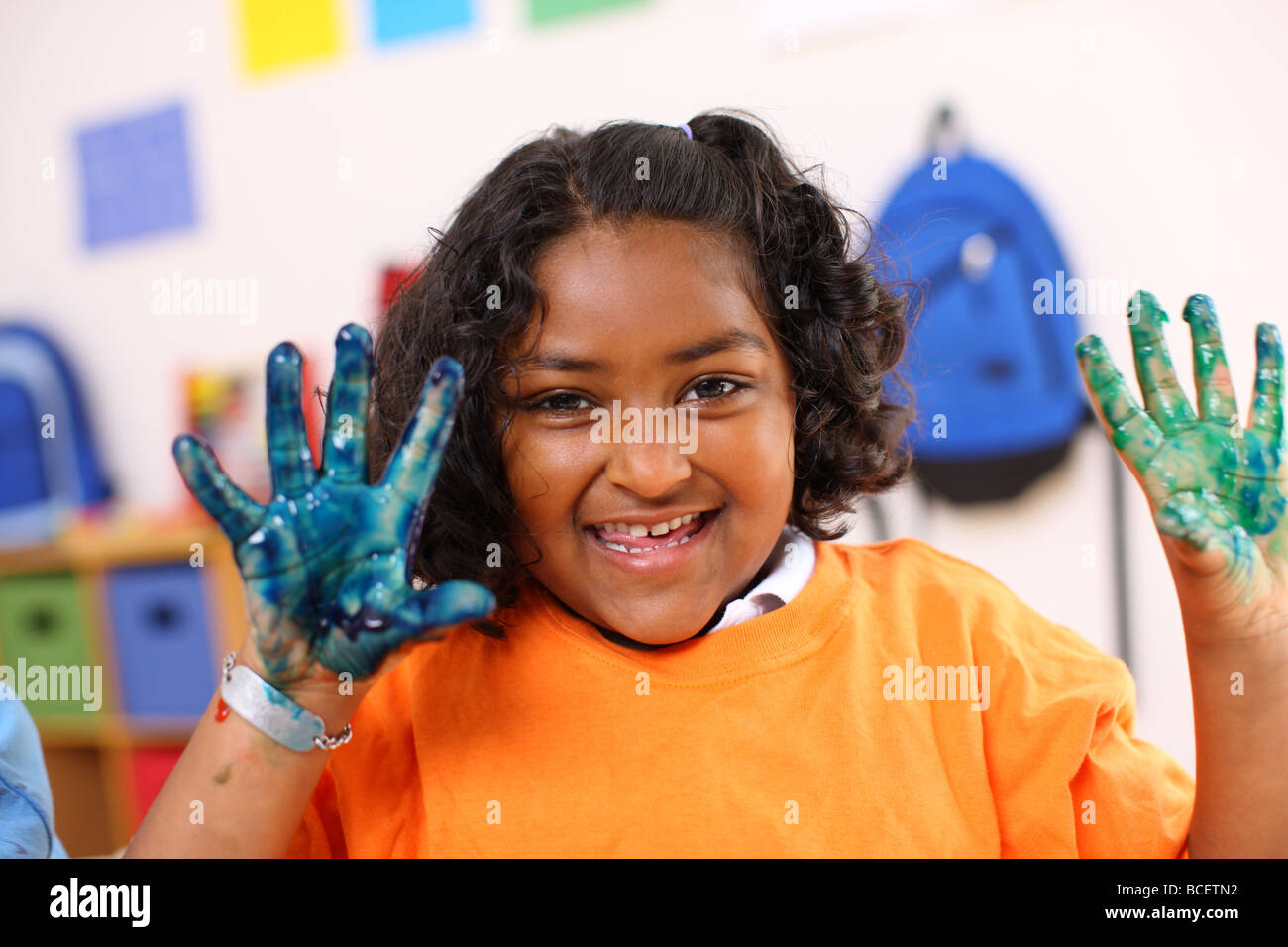 Preschool girl with hands covered in paint Stock Photo