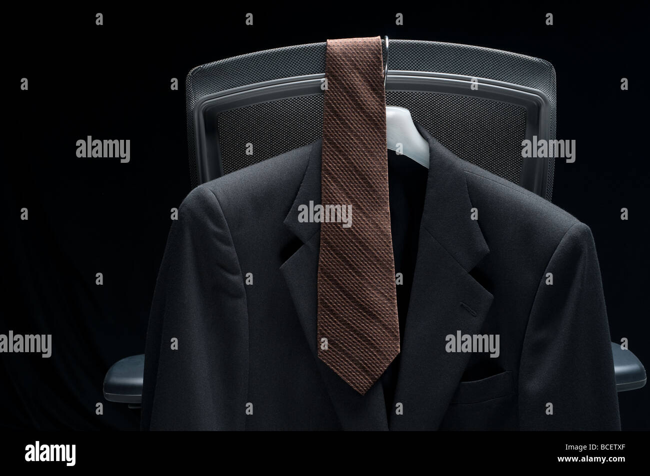 Business jacket and tie hanging on a chair Stock Photo