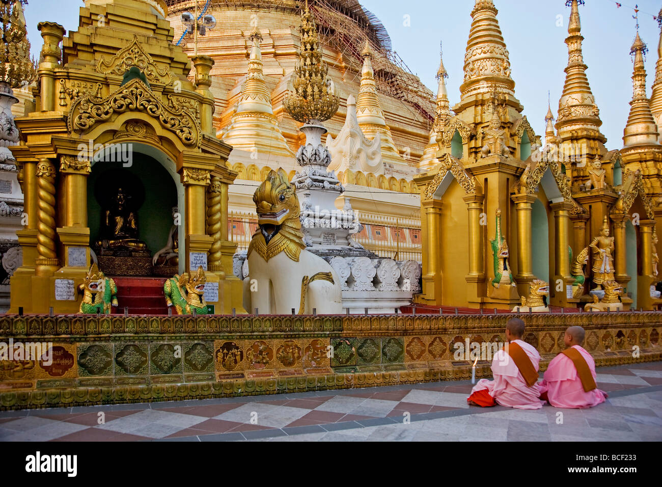 Myanmar, Burma, Yangon. Two young Buddhist nuns pray at the Shwedagon Golden Temple complex. Stock Photo