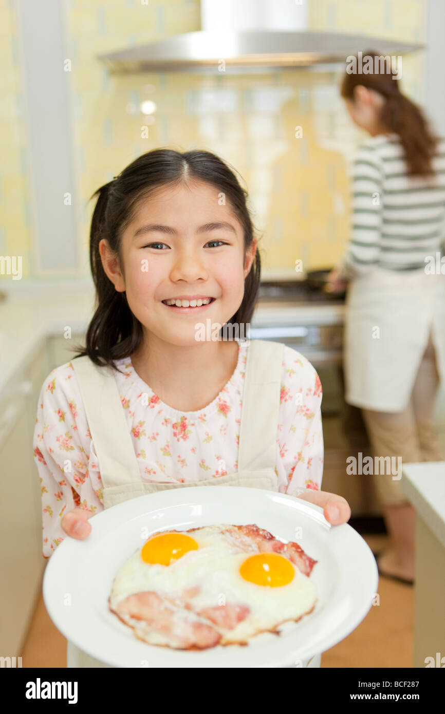 Girl holding plate of bacon egg Stock Photo