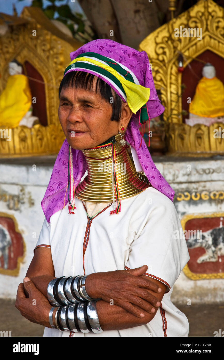Myanmar, Burma, Lake Inle.  A Padaung woman prays at a Buddhist shrine. Her traditional heavy brass necklace Stock Photo