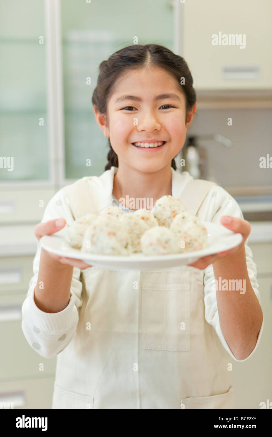 Girl holding plate of rice ball Stock Photo