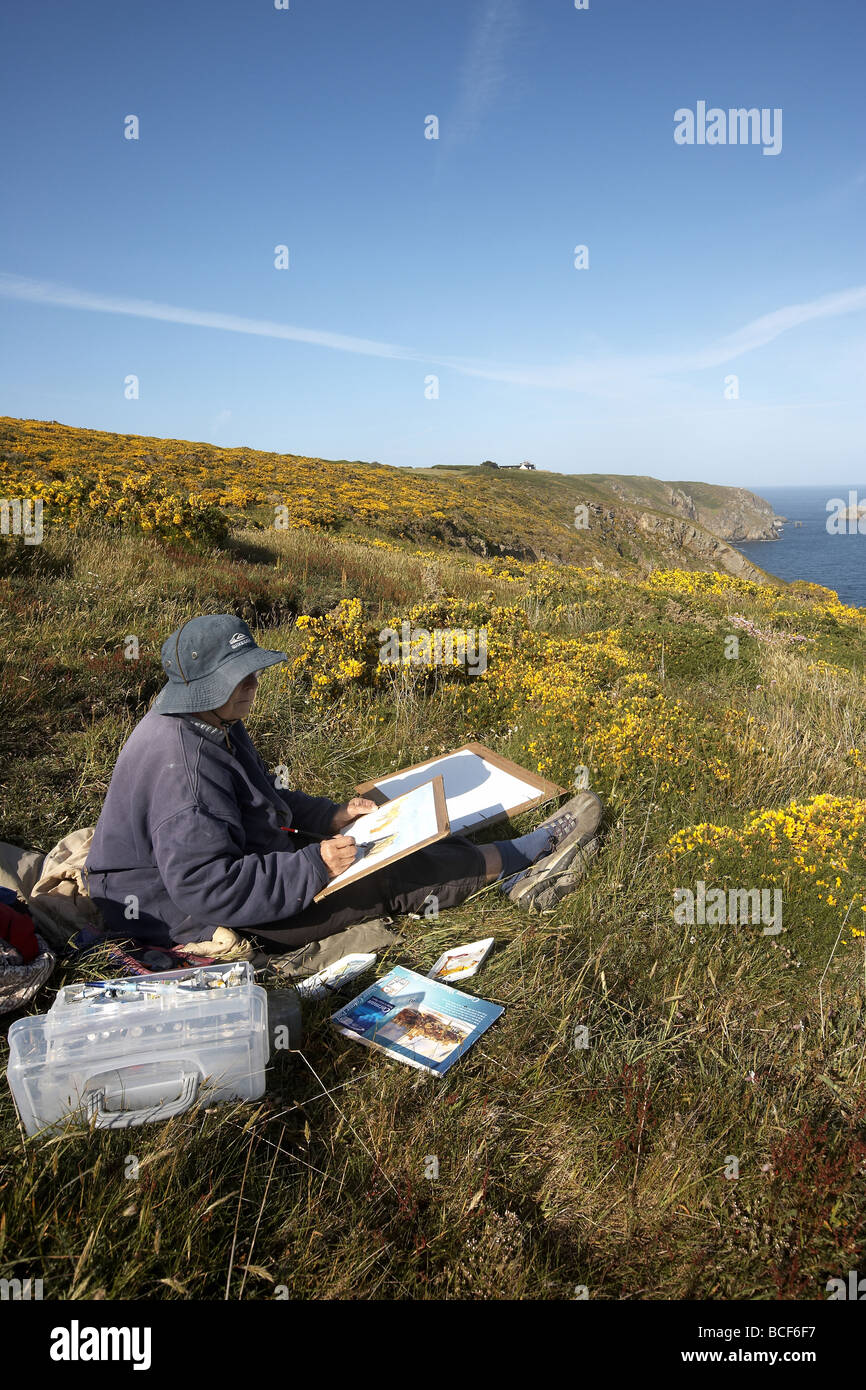 Artist painting the beautiful coastline of Alderney Channel Island UK Stock Photo