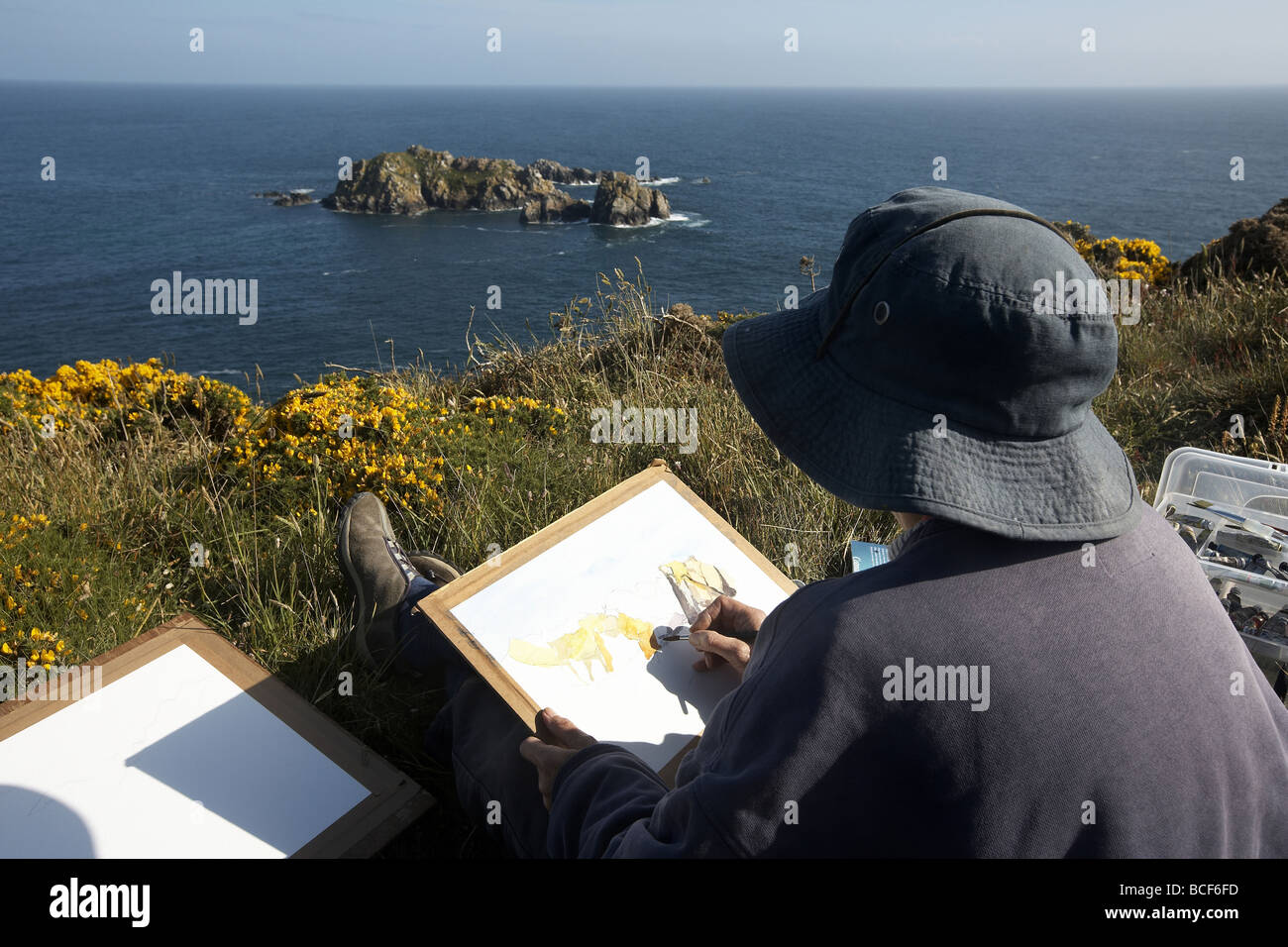 Artist painting the beautiful coastline of Alderney Channel Island UK Stock Photo