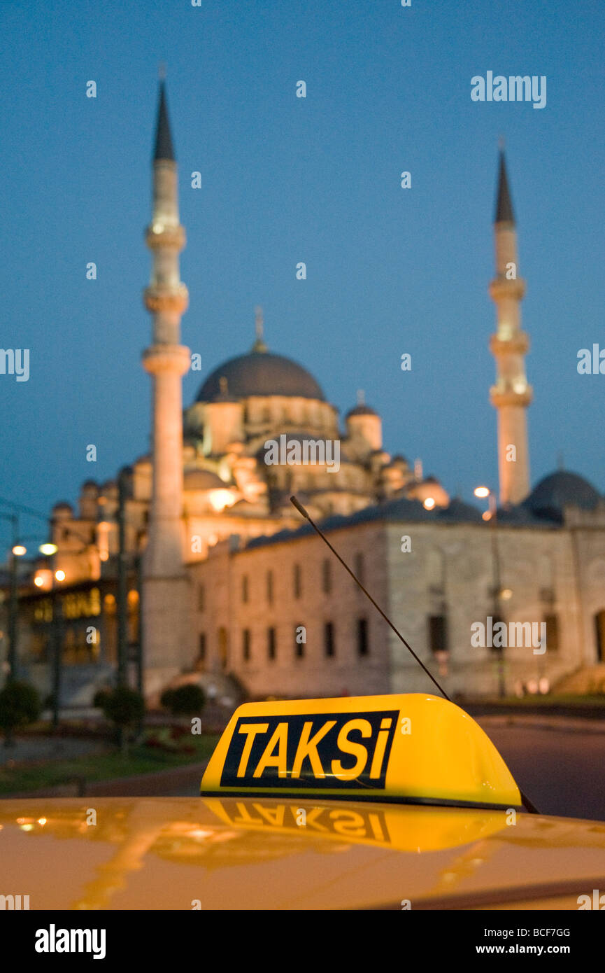 A yellow taxi Taksi cab in front of the Yeni Cami New Mosque in Istanbul Turkey Stock Photo