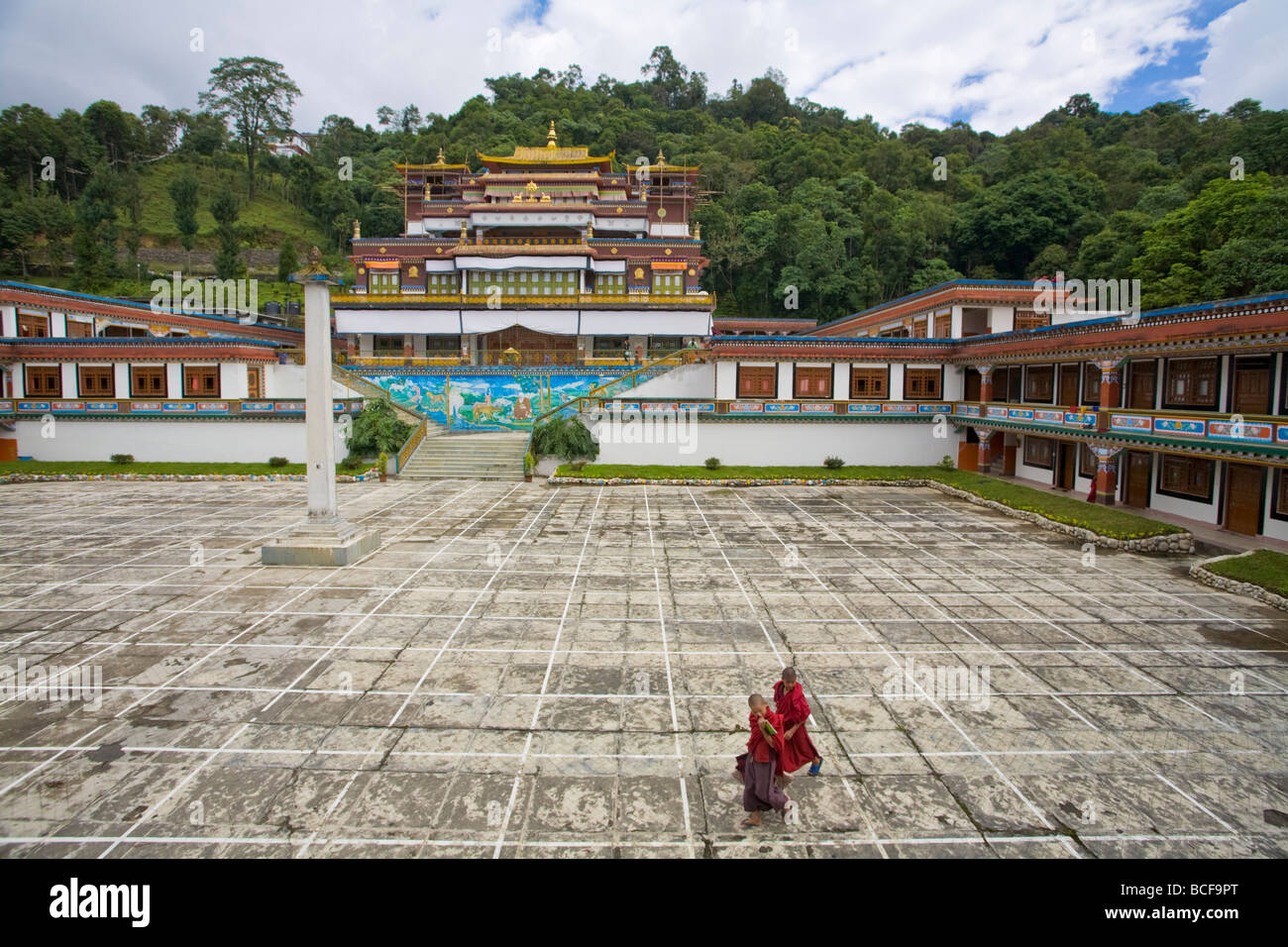 India, Sikkim, Gangtok, Lingdum Gompa, Novice monks walking across courtyard of monastery Stock Photo