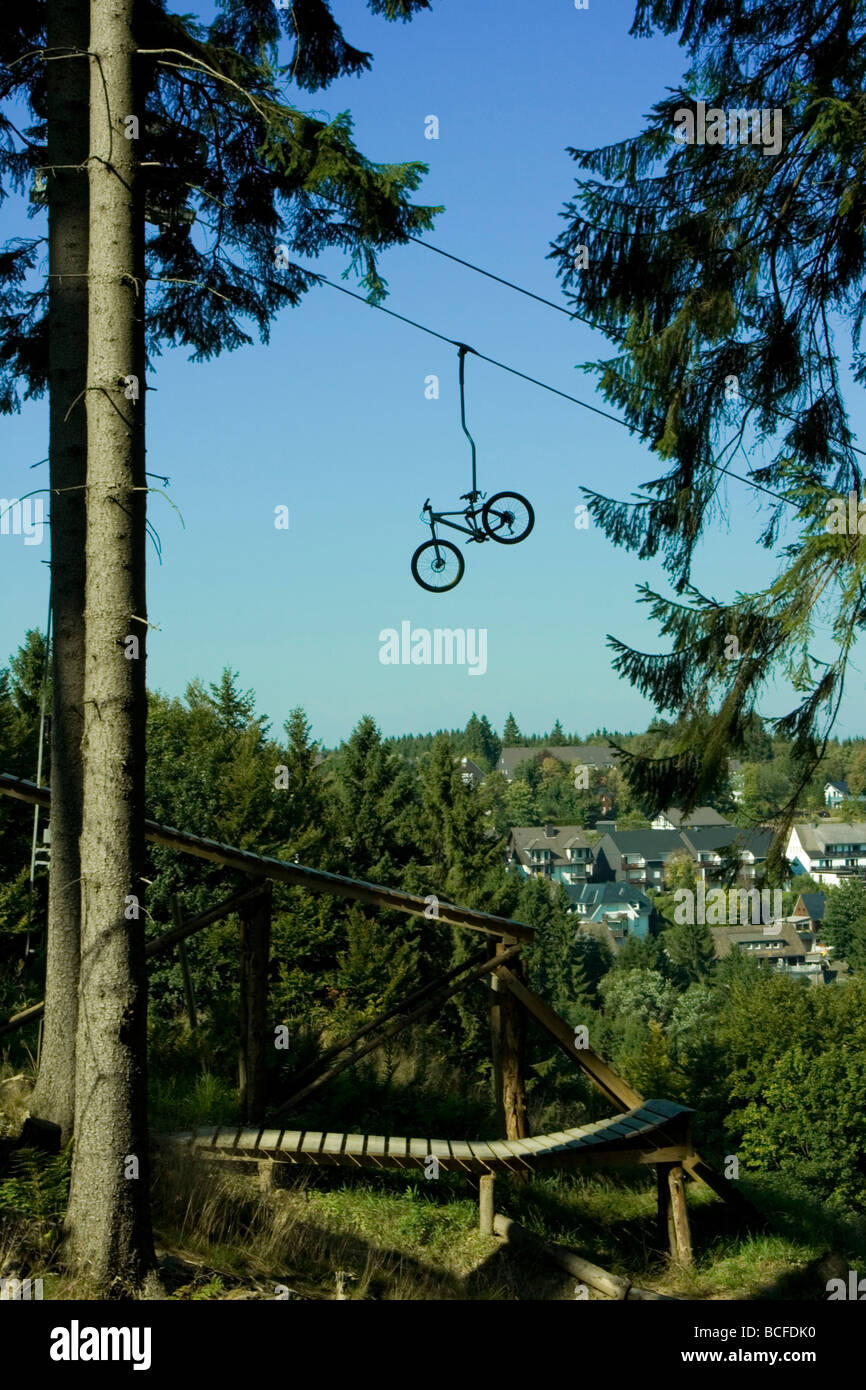 Mountain bike on skilift whit bike jumps below Stock Photo