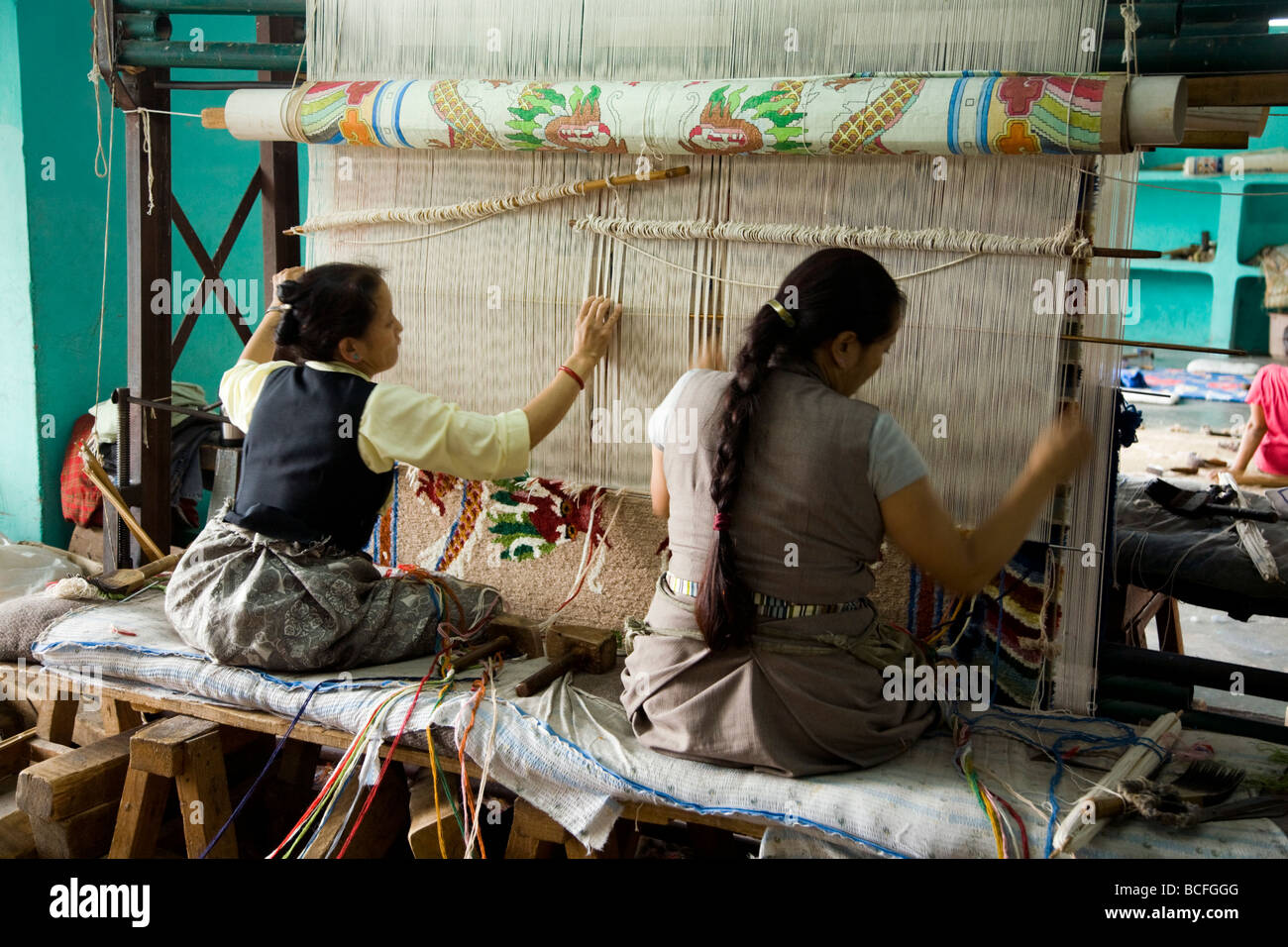 Two women carpet weavers work on a loom at the Tibetan Handicraft Center. McCleod Ganj. Himachal Pradesh. India. Stock Photo