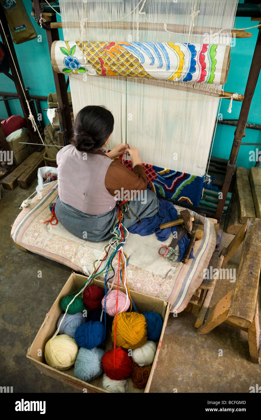 Woman carpet weaver works on a loom at the Tibetan Handicraft Center. McCleod Ganj. Himachal Pradesh. India. Stock Photo