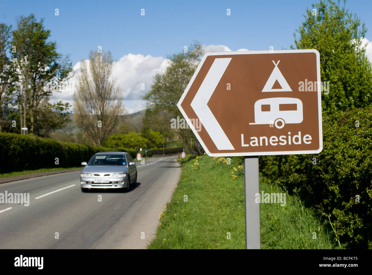 Brown road sign showing the way to a camping and caravanning site in the Peak District Derbyshire England Stock Photo