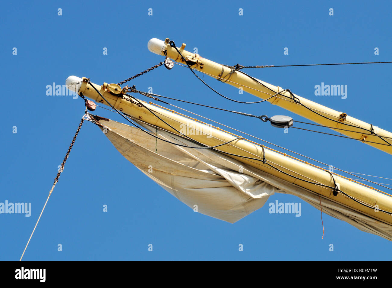 Sailboat yardarm with furled sail rigging and block and tackle Stock Photo
