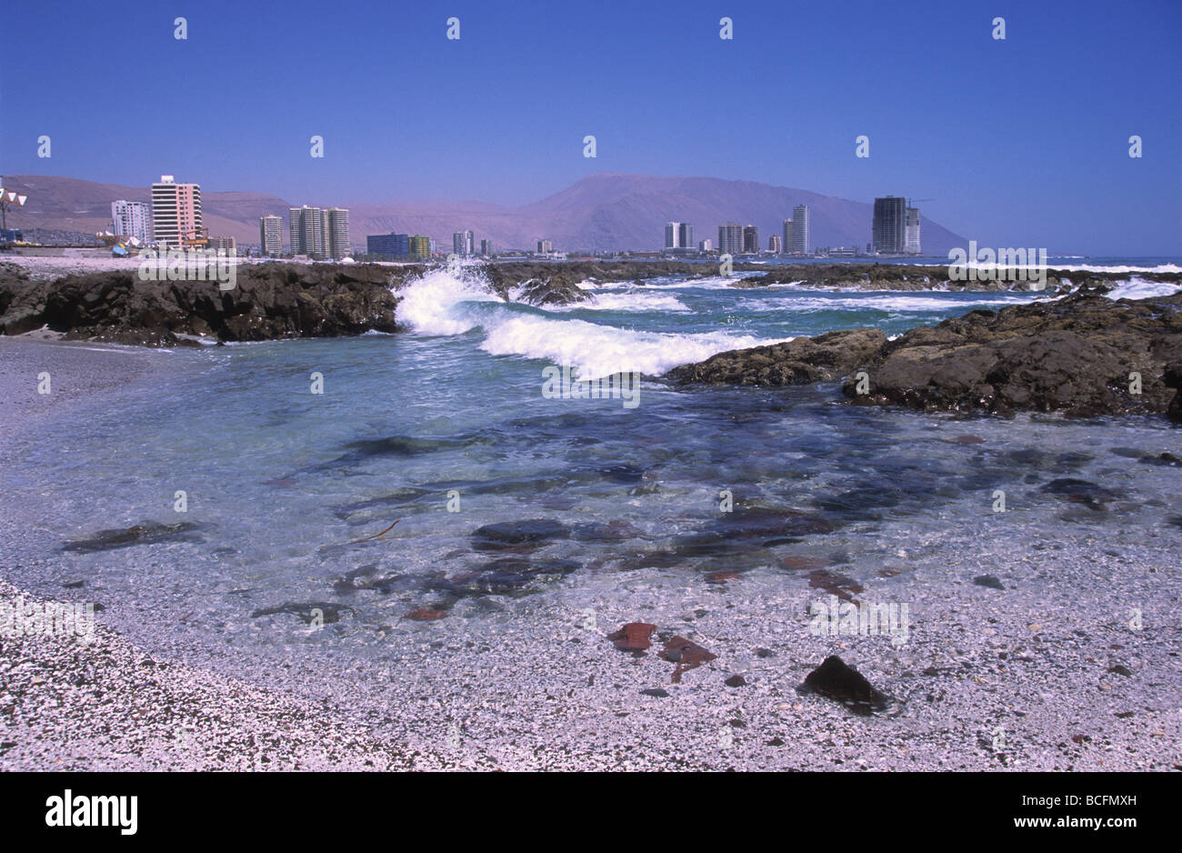 View along coast to modern skyscrapers in distance, Iquique , Chile ...