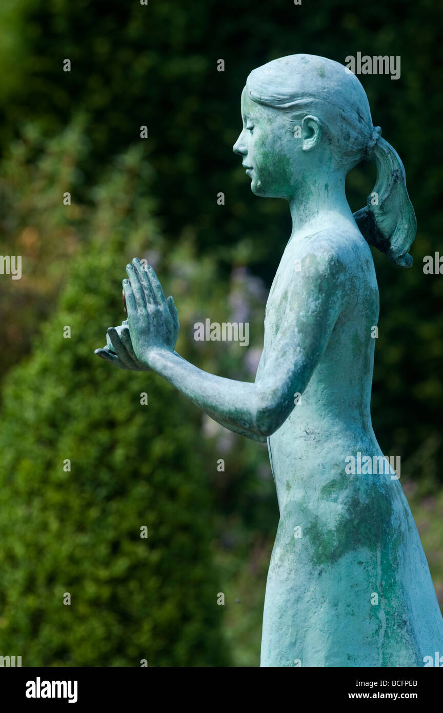 Girl statue called the 'lamp of wisdom'. Ornamental garden statue at