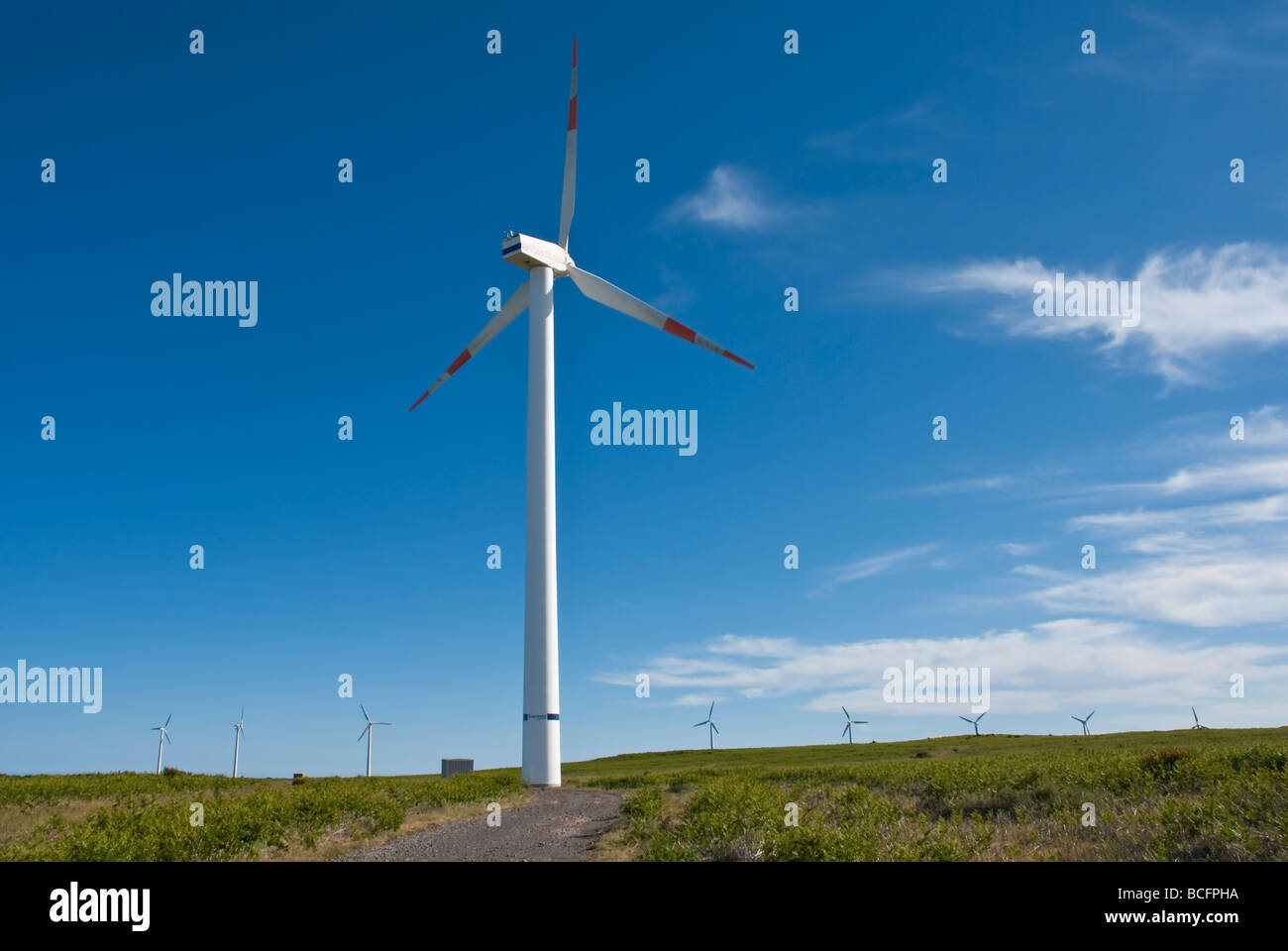 Wind turbines on hill, with blue sky Stock Photo - Alamy