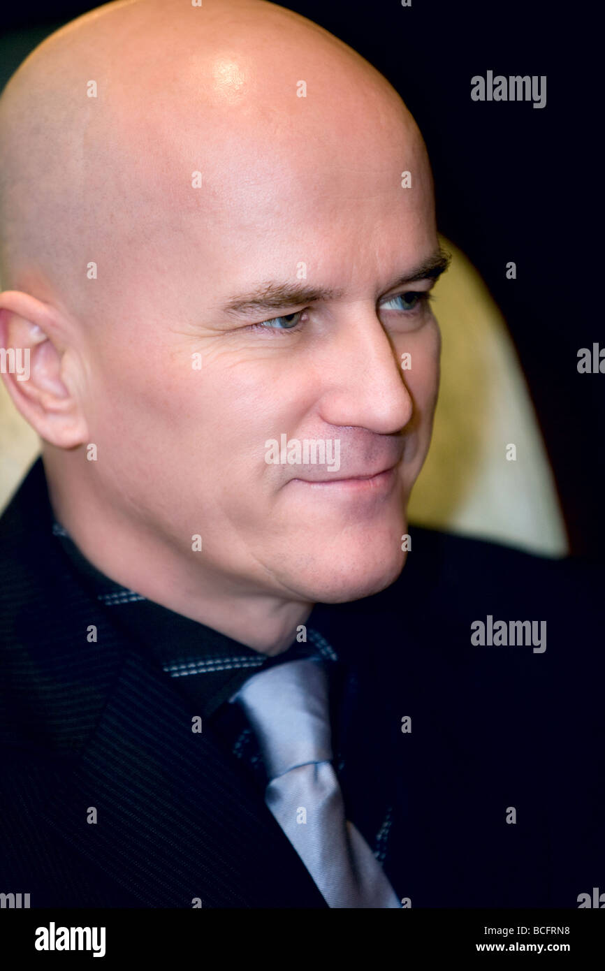 Profile of a bald man in his late 40's wearing a dark suit. Stock Photo