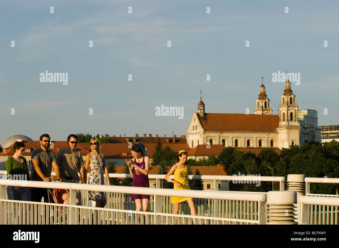 People modern and fashionable walk on footbridge across Neris River Vilnius Lithuania Stock Photo