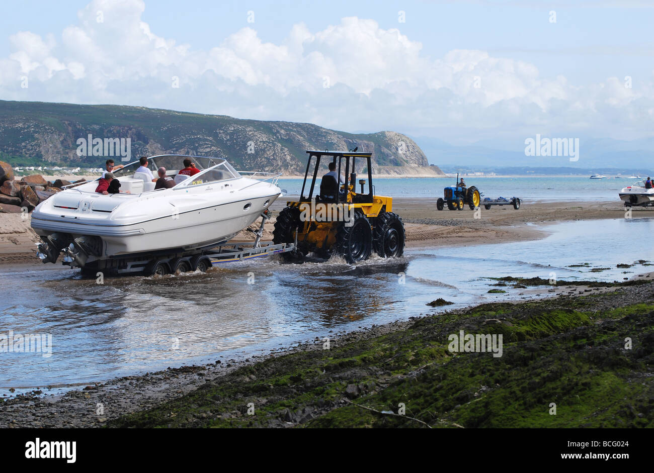 Tractor pulling boat down river to launch at low tide no 2733 Stock Photo