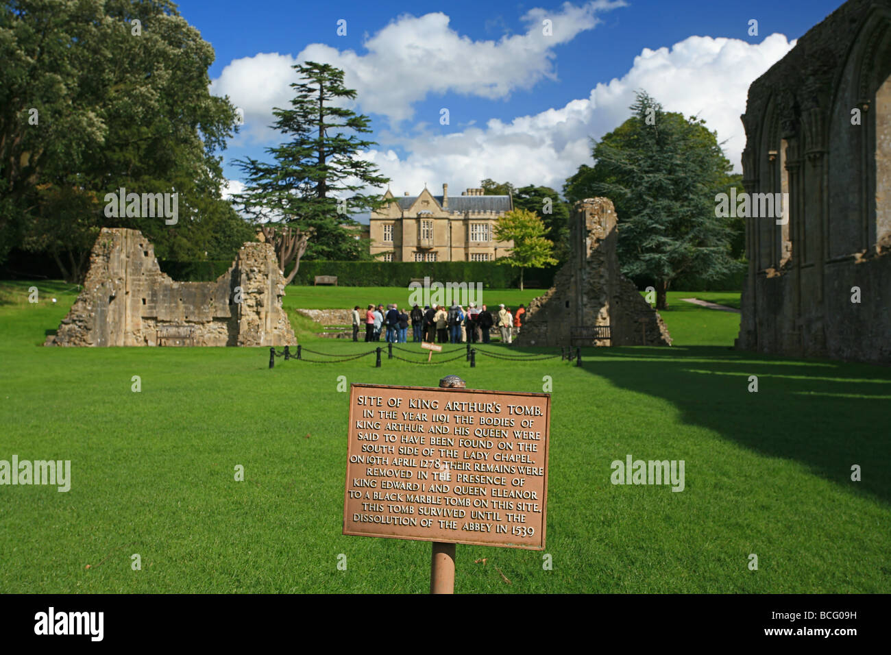 A group of visitors get a guided tour of Glastonbury Abbey ruins at the site of King Arthurs tomb, Somerset, England, UK Stock Photo