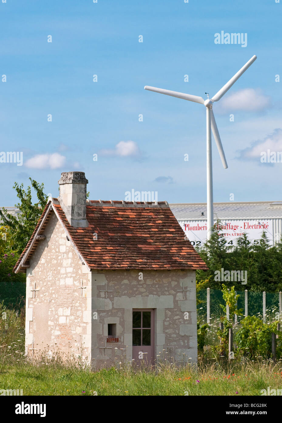 Small house and wind turbine - Indre-et-Loire, France. Stock Photo