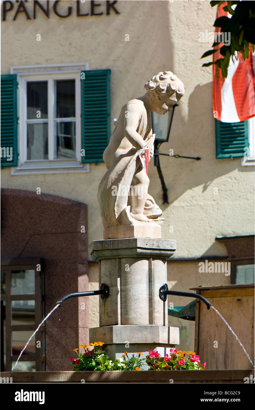 Stone statue of a boy and fish in the town square at Zell am See in Austria. Stock Photo