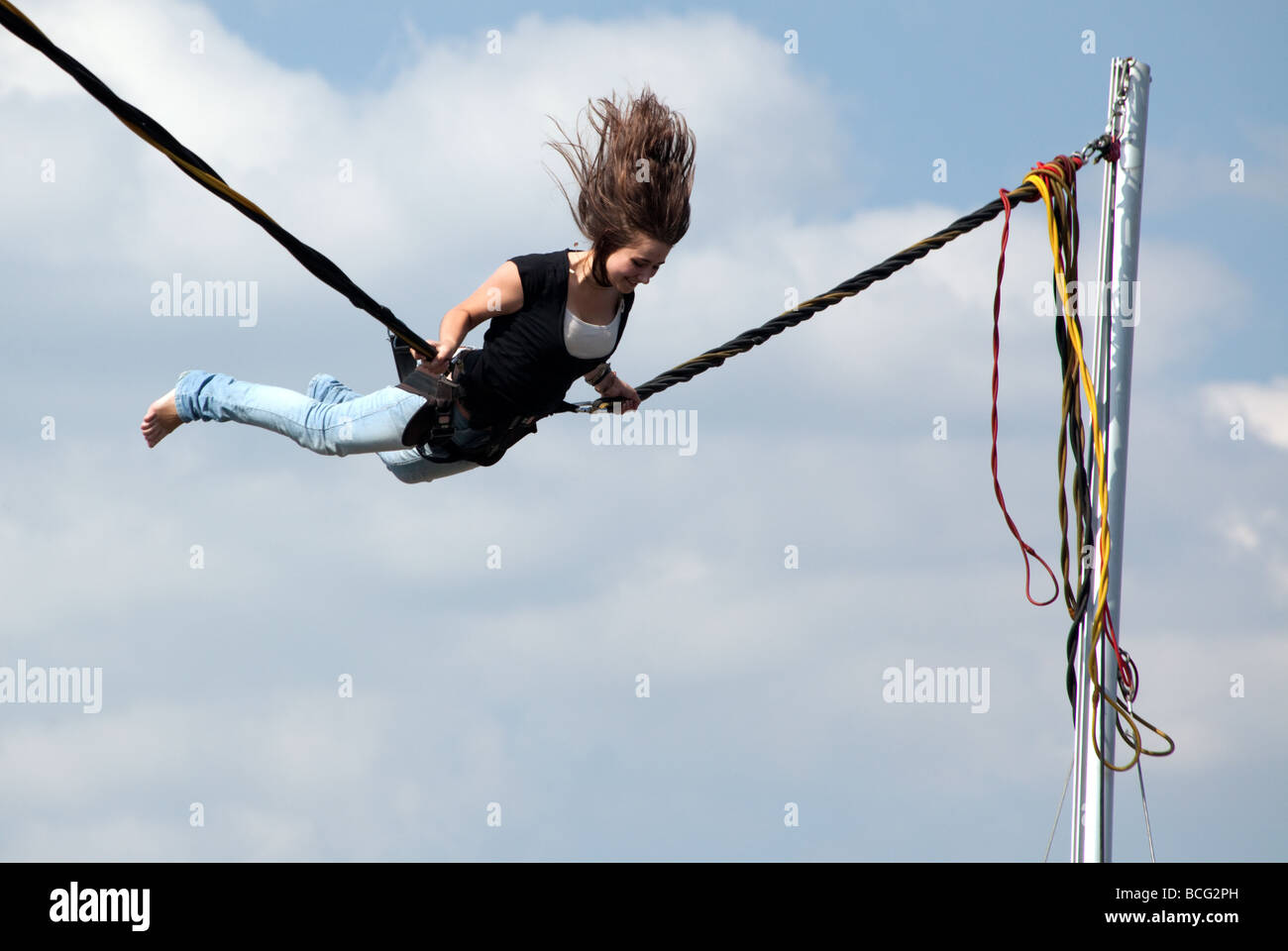 A young woman bouncing up and down doing somersaults on a fairground ride in Kiev Stock Photo