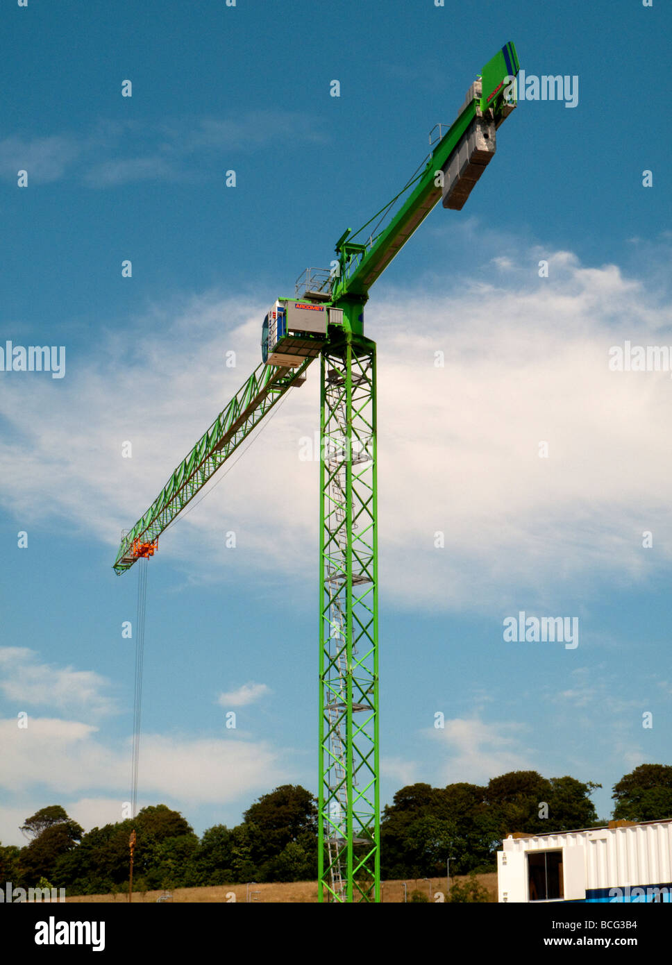 A green tower crane being used for building construction Stock Photo