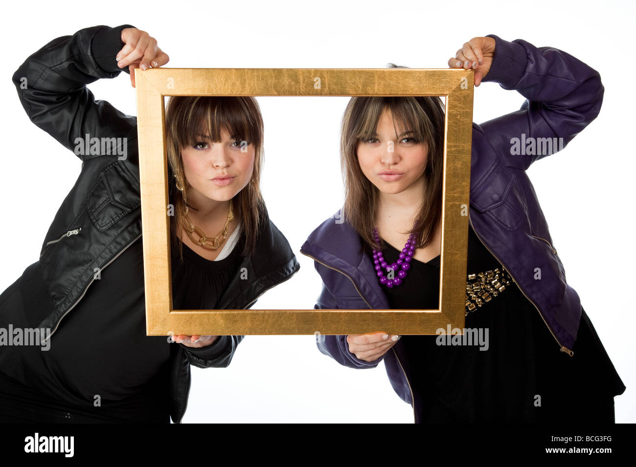 Twin girls holding a picture frame isolated against white Stock Photo