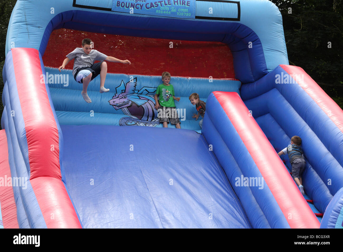 Children on an inflatable slide at an English village show. Ambergate, Derbyshire, England, U.K. Stock Photo