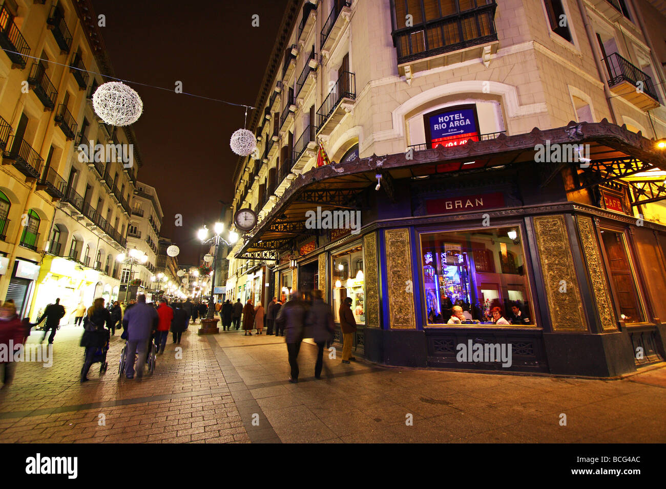 People and tourist walking at night past cafè and shops in downtown