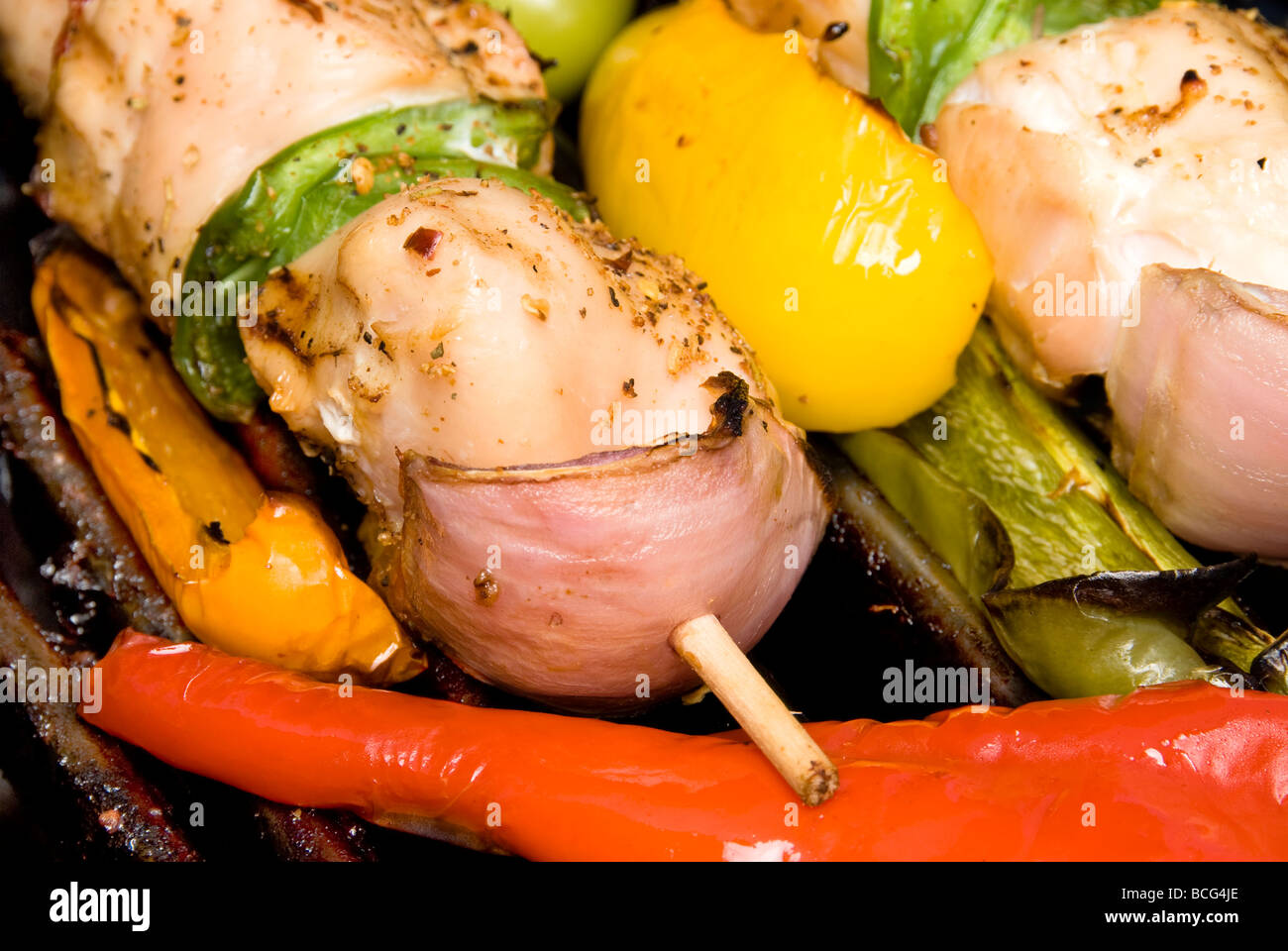 A grilling chicken kebab with bell peppers and onions being barbecued for a picnic Stock Photo