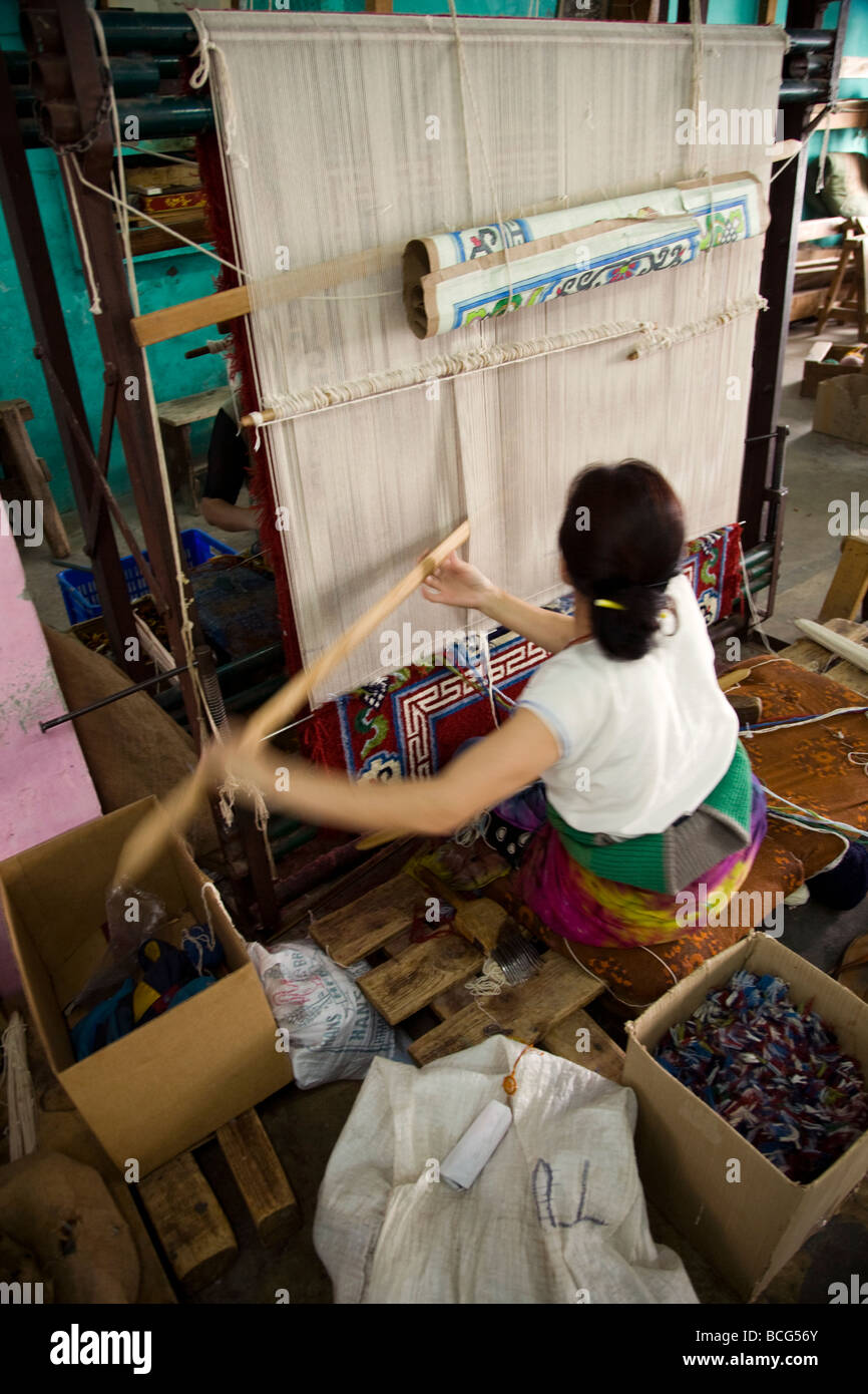 Woman weaver works on a loom at the Tibetan Handicraft Center. McCleod Ganj. Himachal Pradesh. India. Stock Photo