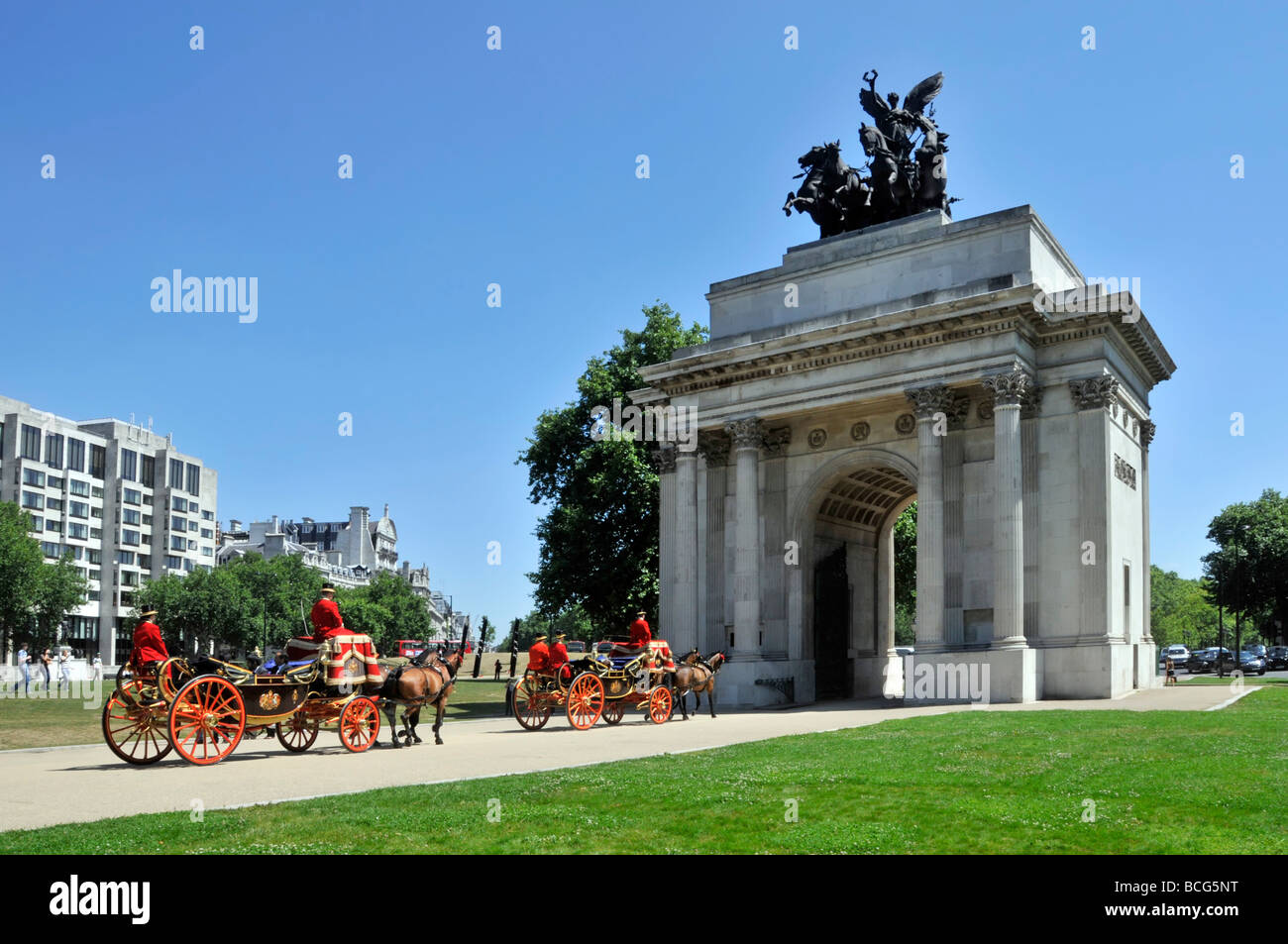 Two horse drawn open carriages about to pass through Wellington Arch Hyde Park Corner London England UK Stock Photo