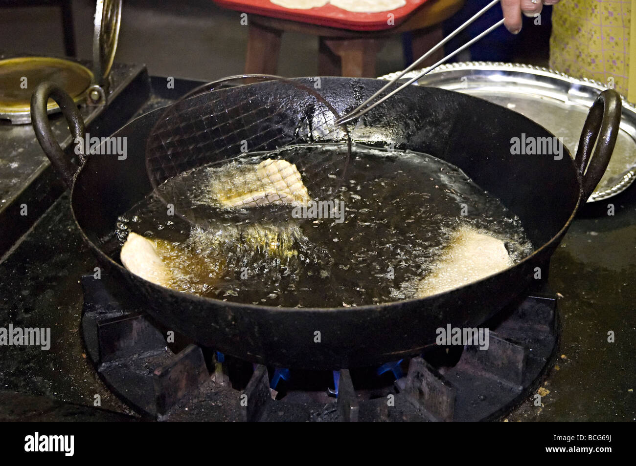 poppadoms being deep fat fried in a hindu temple in the uk in their