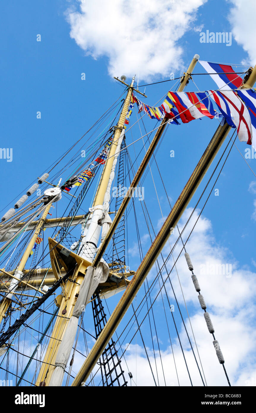 Looking up ships mast with flags rigging shrouds lines and yardarms Stock Photo